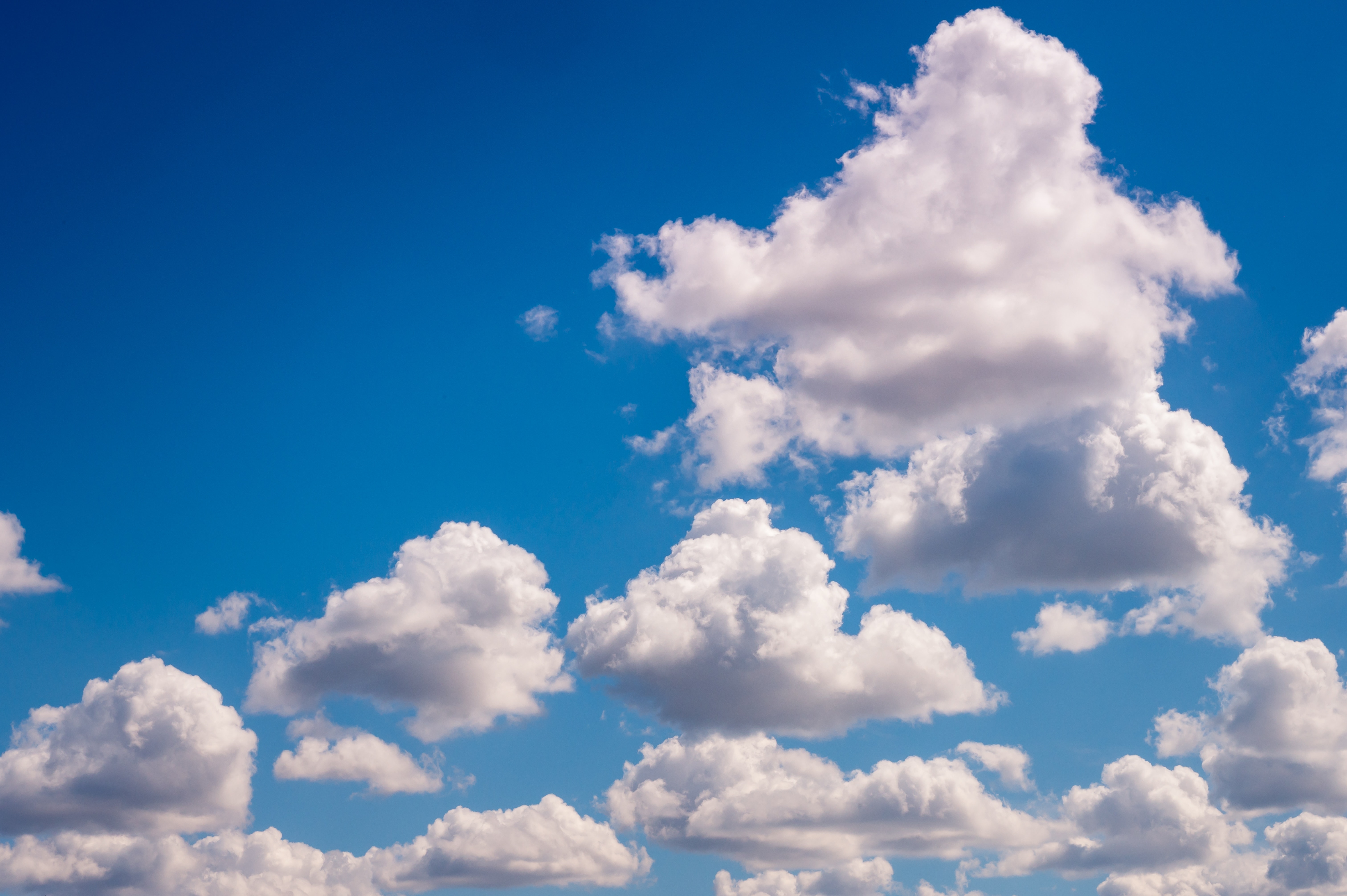 Vita fluffiga moln på blå himmel.