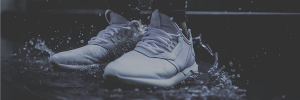 Vita joggingskor i vattenpöl
